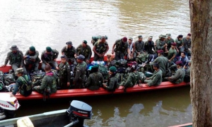 Membros da guerrilha das Forças Armadas Revolucionárias da Colômbia-Exército do Povo (FARCs-EP), viajando pelo rio Mecaya no Putumayo, para encaminhar-se às zonas de desarmamento.